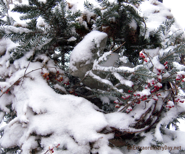 Stone Bunny buried in a wreath covered with snow