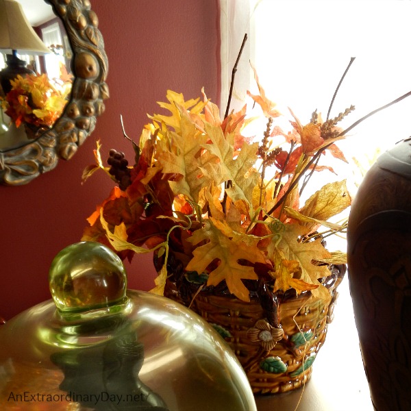 A majolica basket filled with faux leaves and tips for dressing a living room for fall. 