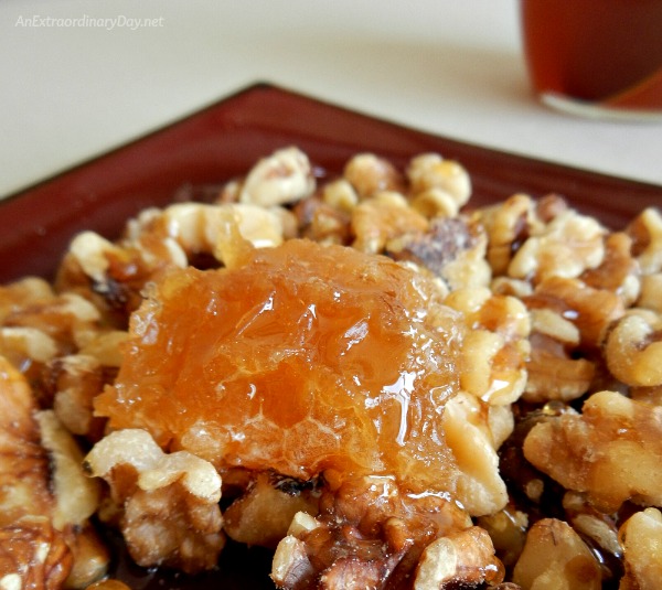 Sweeten their Day with Love and Honey - Honeycomb on a plate of nuts drizzled with honey.