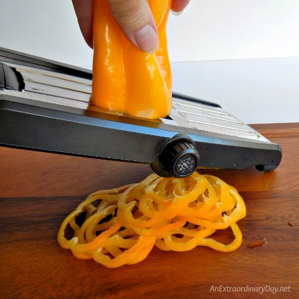 Slicing vegetables super thin with vegetable mandoline for a simple summer stacked sandwich at AnExtraordinaryDay.net