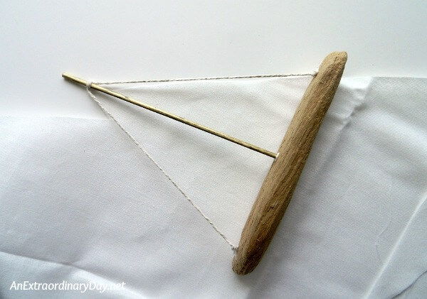 Make a sail for your driftwood Christmas ornament sailboat with this tutorial from AnExtraordinaryDay.net