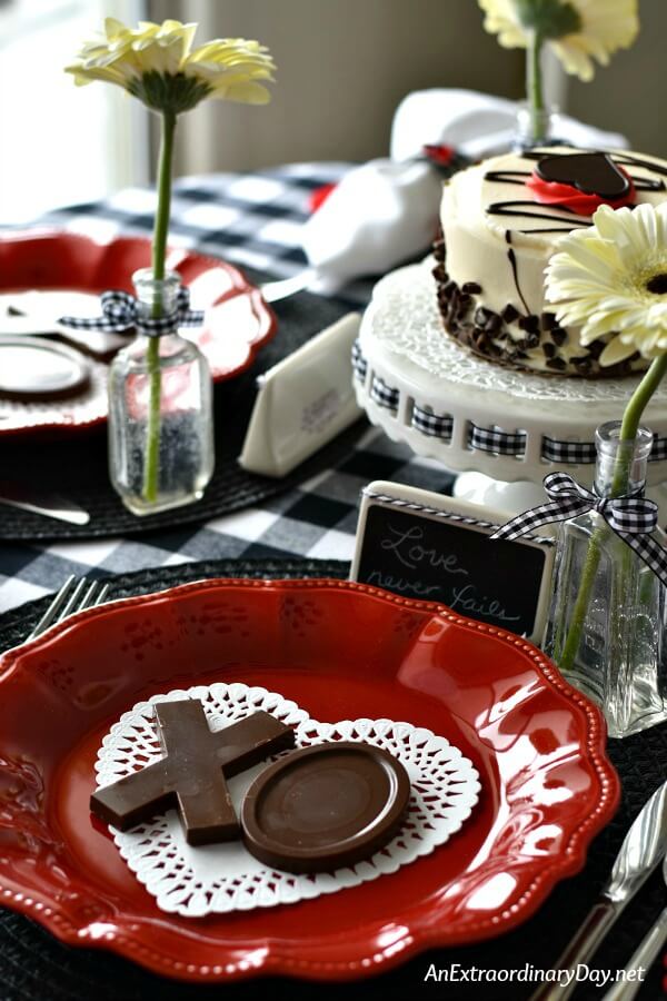 Simple Valentine Table Setting with Red Plates on a Black and White Check Tablecloth - AnExtraordinaryDay.net