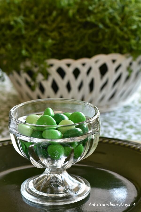 Tiny vintage glass dessert bowl filled with M&M's green mint candies for a St. Patrick's Day table setting - AnExtraordinaryDay.net