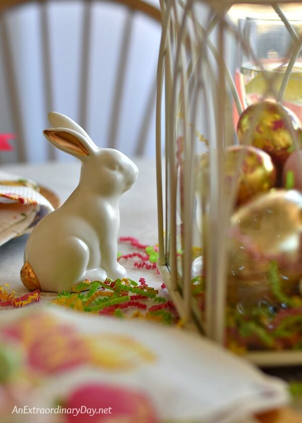 White and gold rabbit adds to the decor of a gold and pastel Easter tablescape - AnExtraordinaryDay.net