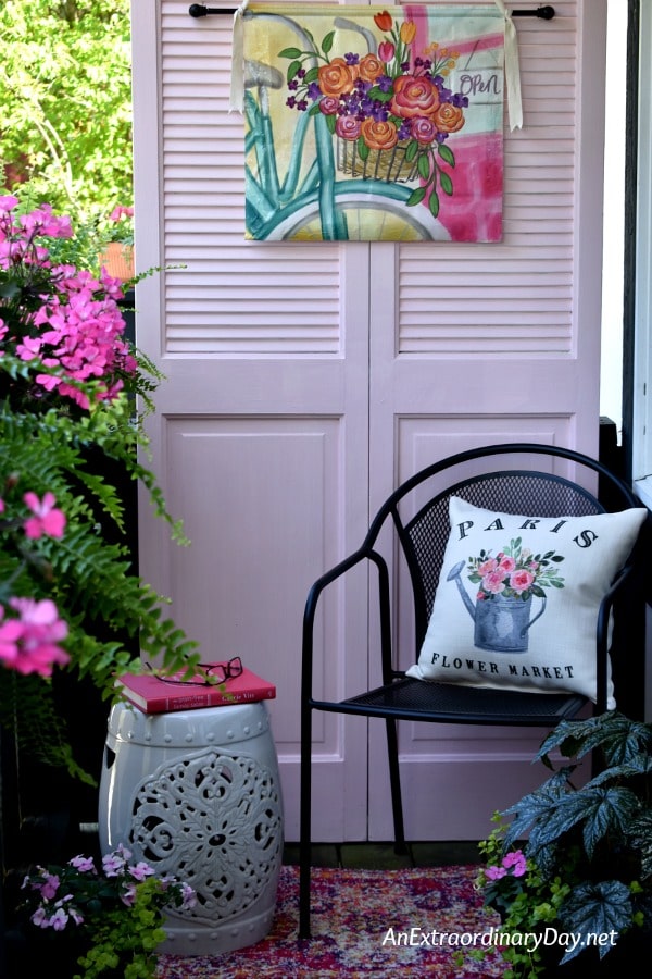 Simple Balcony Sitting Area with a Pink Door for Backdrop and Black WI Chair for Sitting and Ceramic Garden Stool for Book or Drink